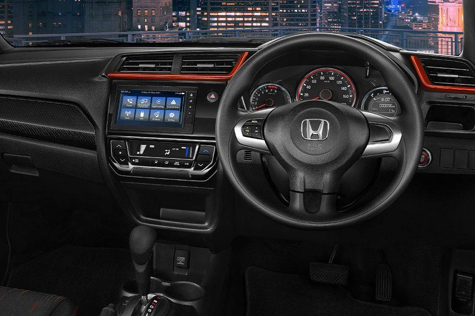 Giá xe Honda Brio cũ cập nhật 5 The driver's perspective of the Honda Brio's dashboard, featuring the steering wheel, instrument cluster, and infotainment system.