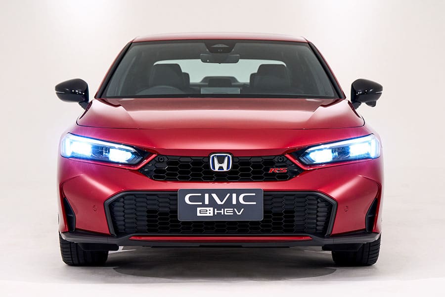 Giá xe Honda Civic cũ cập nhật 7 Front view of a red Honda Civic e:HEV with illuminated LED headlights.