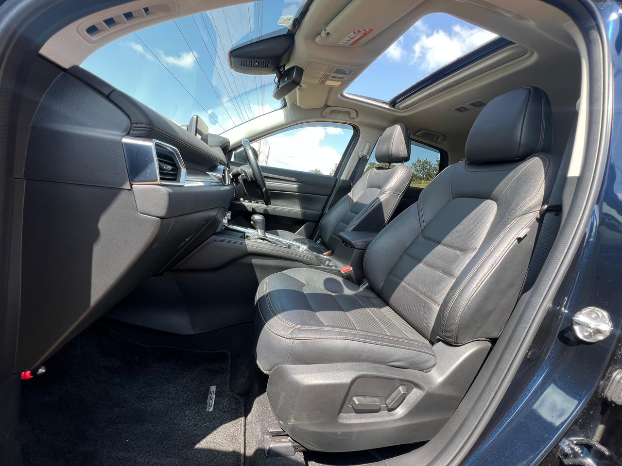 So sánh các phiên bản Mazda CX-5 tại Việt Nam: Đánh giá chi tiết và hướng dẫn mua xe 6 Interior view of Mazda CX-5 showing premium leather seats and open sunroof.