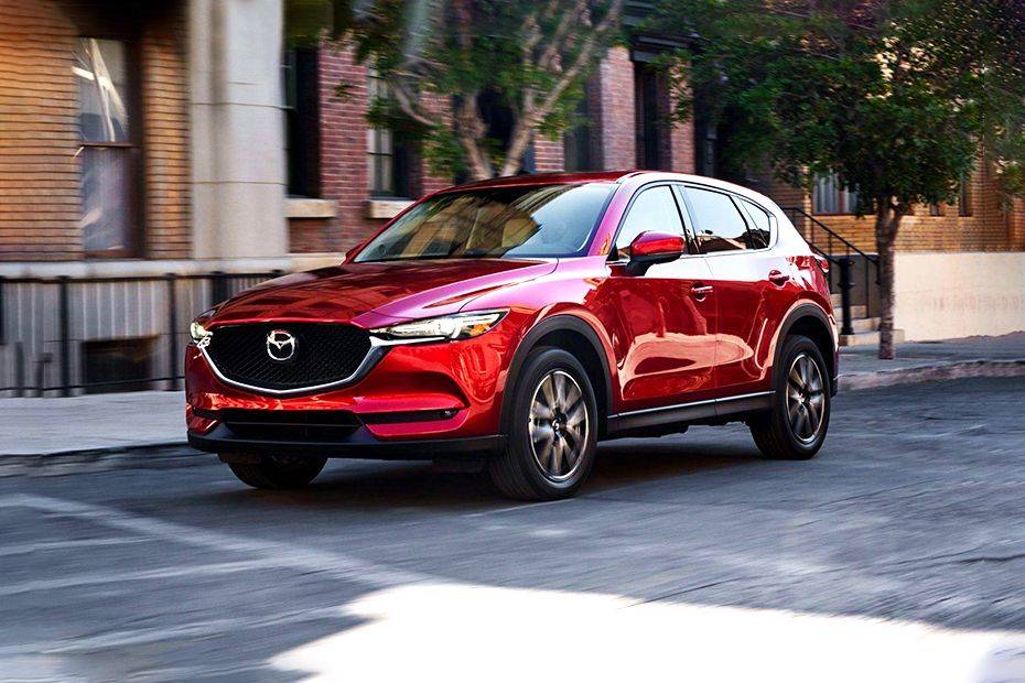 Sự khác biệt giữa Mazda CX5 Deluxe và Mazda CX5 Luxury 2025: Phân tích chi tiết, kinh nghiệm chọn phiên bản tối ưu 4 Red Mazda CX-5 Luxury 2025 driving in an urban setting, showcasing its sleek exterior design.