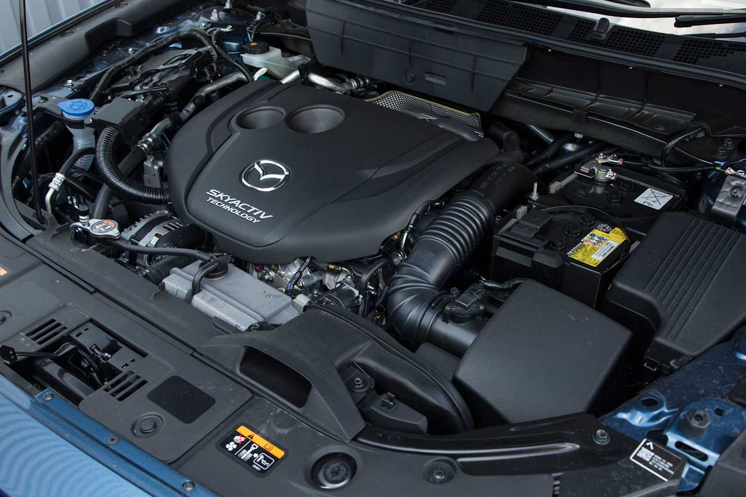 So sánh các phiên bản Mazda CX-5 tại Việt Nam: Đánh giá chi tiết và hướng dẫn mua xe 3 Close-up of Mazda CX-5 engine bay featuring Skyactiv-G technology with clear branding and components.