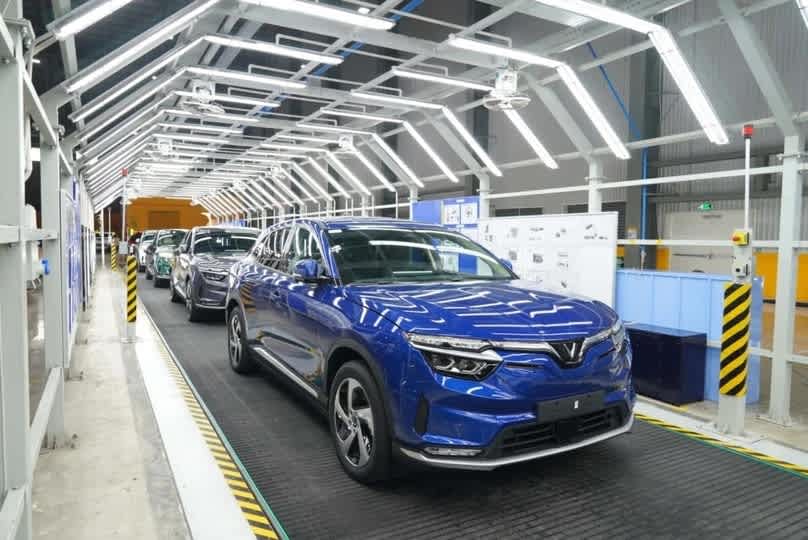 Xe điện VinFast để ngoài mưa có sao không? Đánh Giá Toàn Diện 2025 5 VinFast electric vehicles moving along an assembly line in a manufacturing plant.